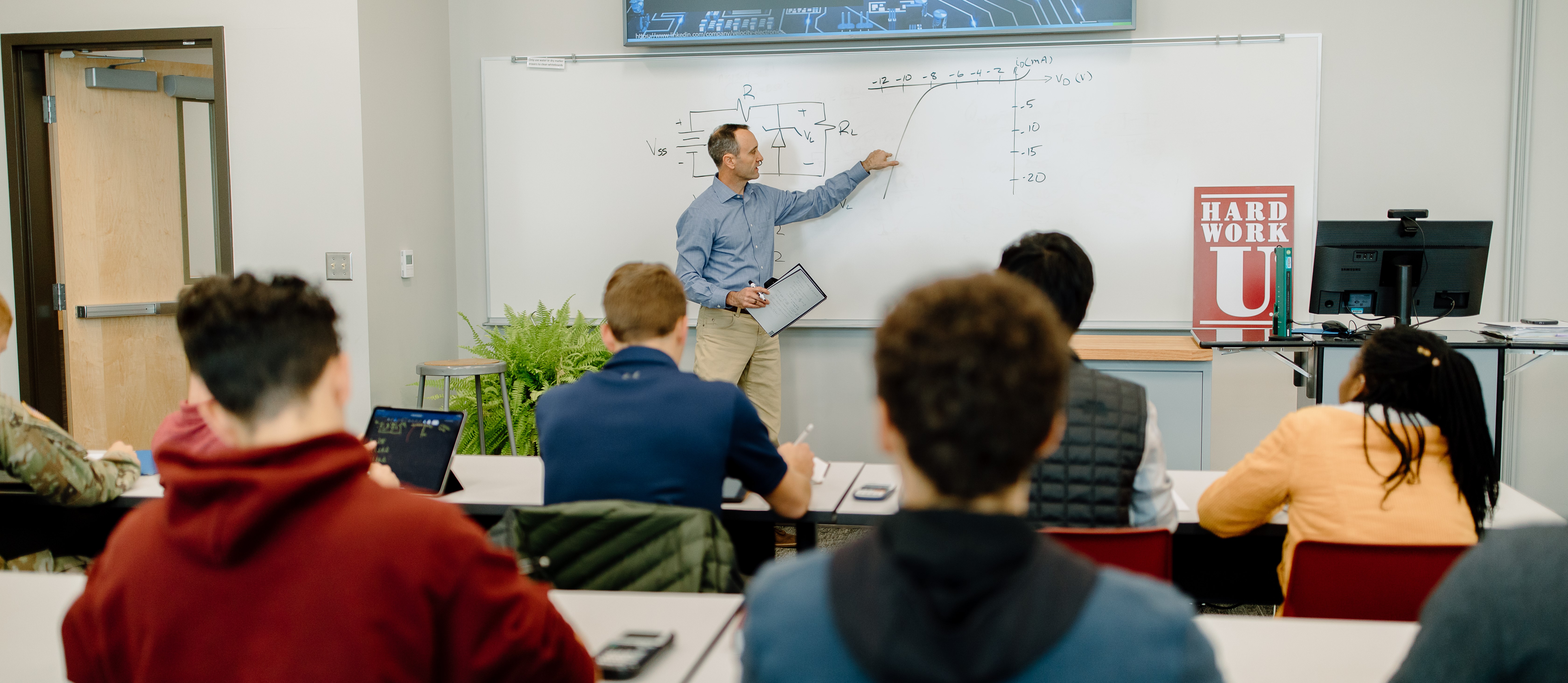 An engineering professor teaching students in a classroom.